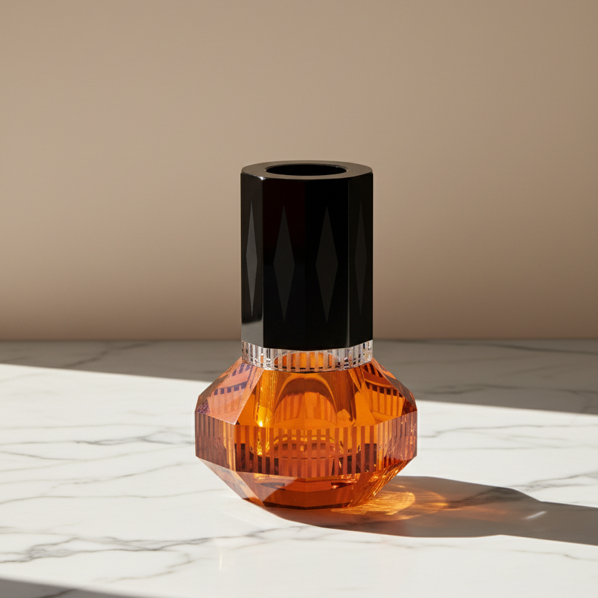 Vase with orange base and black top on a marble surface. Crystal vase