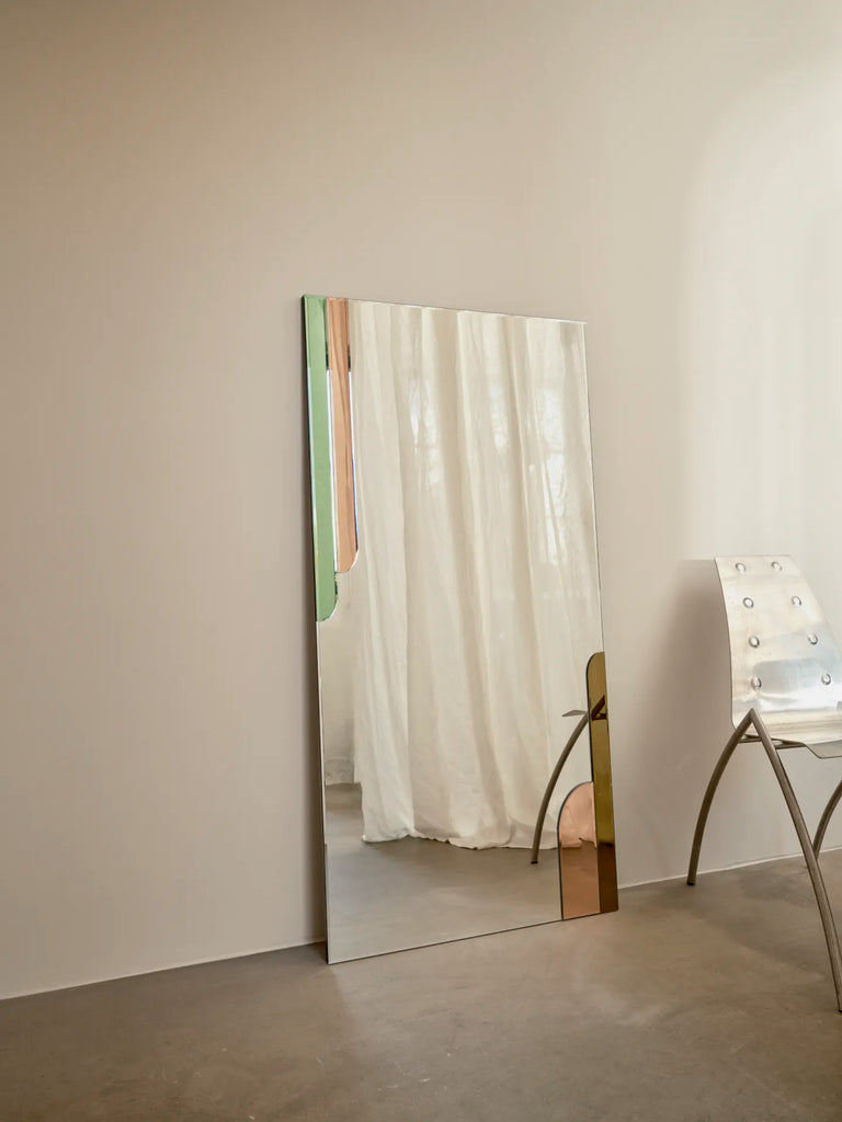 Scandinian Spring Mirror by Reflections Copenhagen, an art nouveau style full-length mirror, with hand-cut green glass accents, mounted vertically in a minimalist interior.